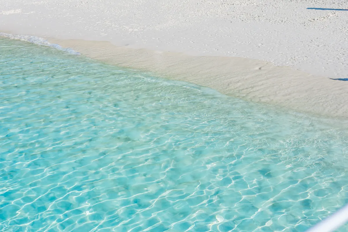 Crystal-clear water over white sand